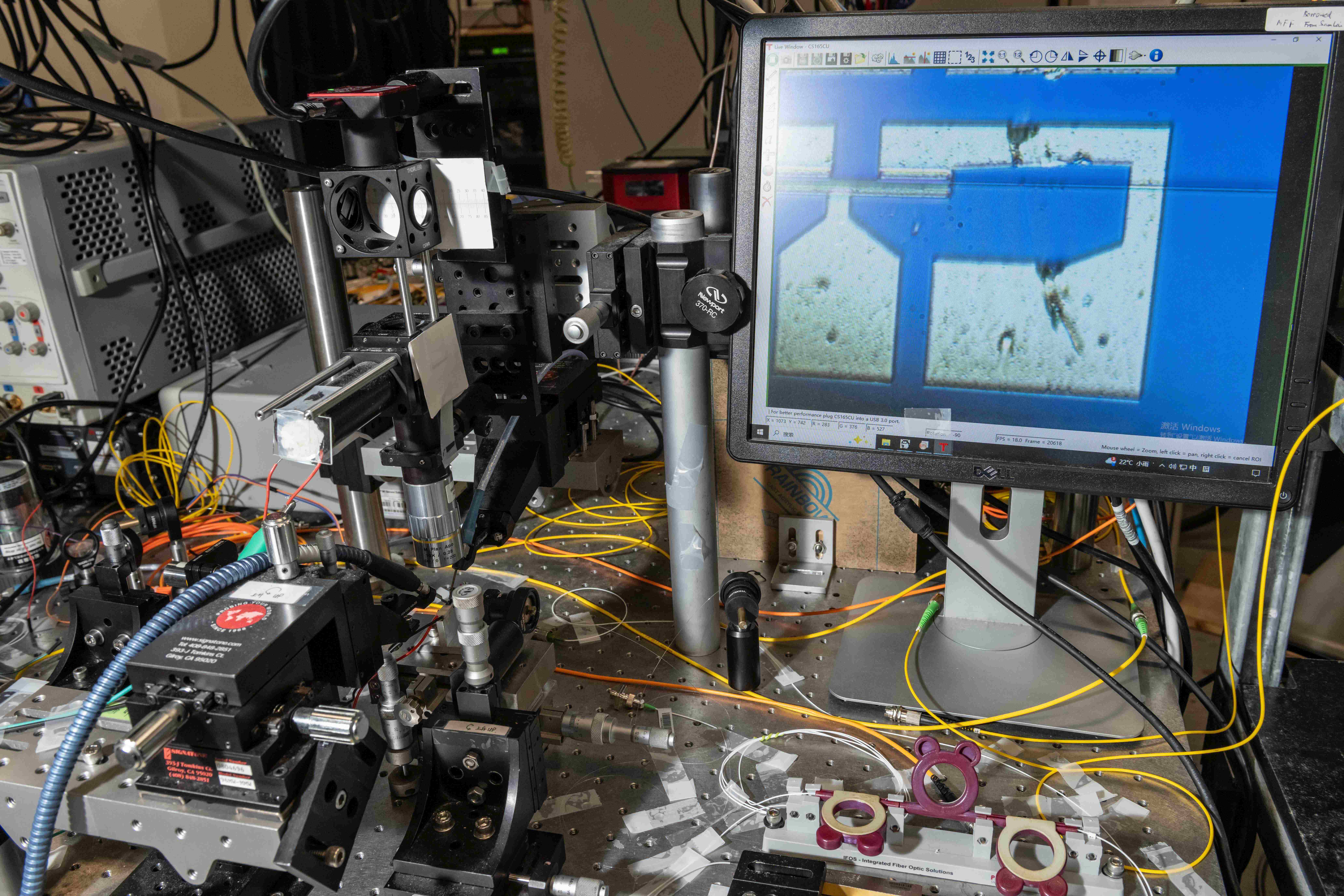The research team’s chip was examined under a microscope, and a germanium-ion-implanted silicon waveguide photodiode was displayed on the screen on the right. 